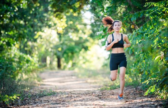 Young fitness woman running on a rural road. Sport woman running