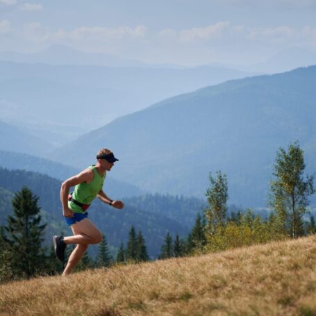 Runner climbing a steep hill in the mountains
